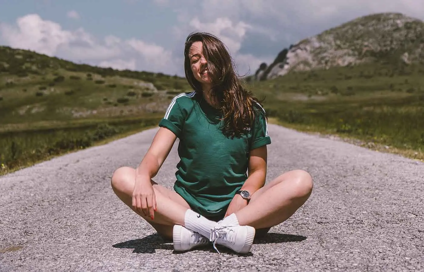 Mujer sentada en la carretera